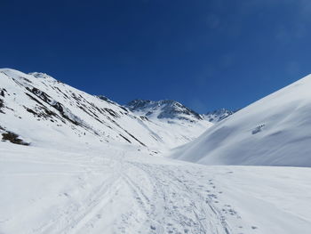 Snow covered mountain against blue sky