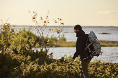 View of backpacker walking at sea