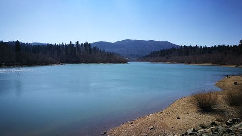 Scenic view of lake against clear blue sky