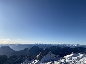 Scenic view of snowcapped mountains against clear blue sky