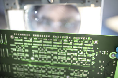 Technician examining motherboard with magnifying glass