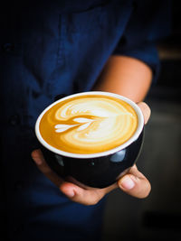 Midsection of man holding coffee