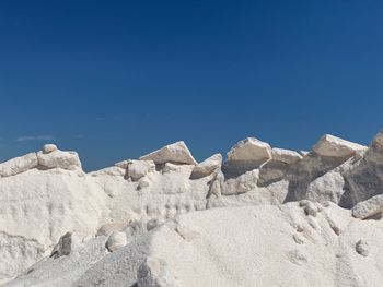 Low angle view of rocks against blue sky