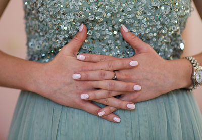 Midsection of woman showing her nail polish on fingernails