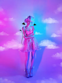 Digital composite image of woman standing against pink blue sky