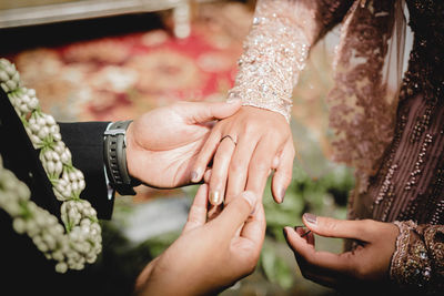 Midsection of couple holding hands