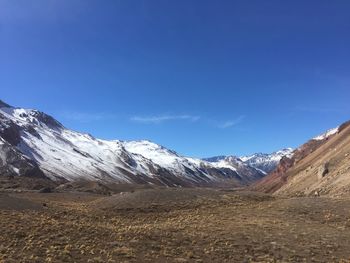 Scenic view of snowcapped mountains against blue sky