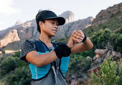 Young man standing against mountain