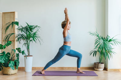 Full length of woman exercising at home