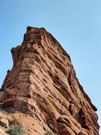 Low angle view of rock formation against clear blue sky