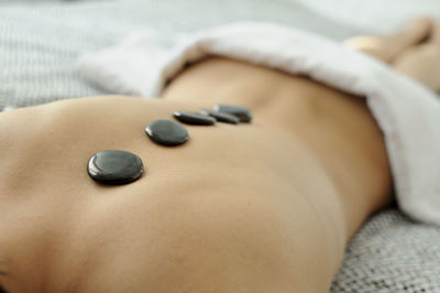 Topless woman receiving lastone therapy at spa