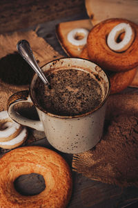 Hot chocolate by doughnuts on table