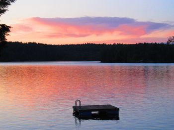 Serene lake with a floating dock at sunset