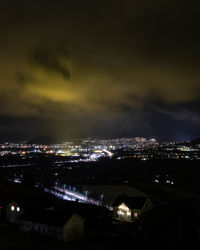 High angle view of illuminated city against sky at night