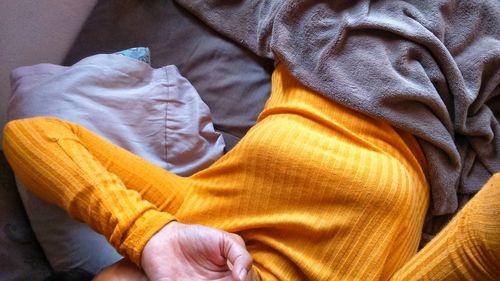 Midsection of woman lying on bed at home