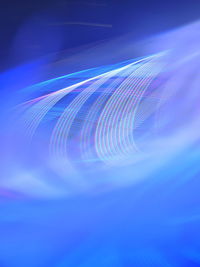 Close-up of illuminated light trails against blue background