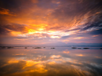 Low angle view of dramatic sky over sea during sunset