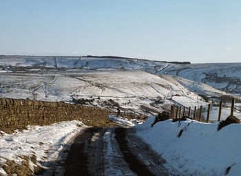 Scenic view of snow covered landscape against clear sky