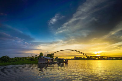 Bridge over river against sky during sunset