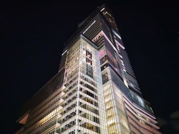 Low angle view of illuminated buildings against sky at night