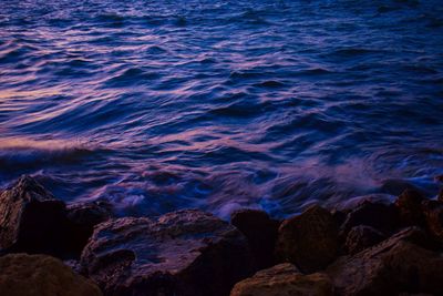 High angle view of rocks at sea during sunset