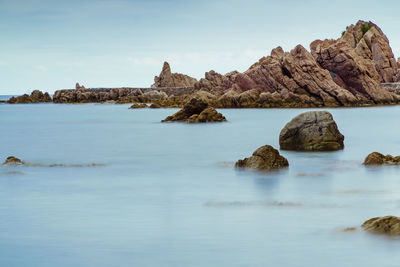 Rocks in sea against sky