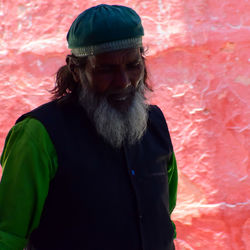 Mid adult man standing against red wall