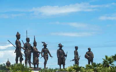 Statues in park against sky