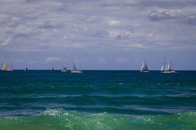 Sailboats sailing on sea against sky