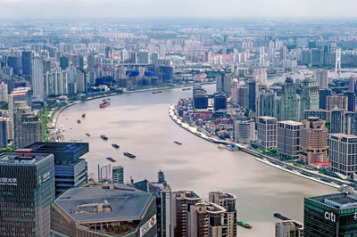 Aerial view of river amidst modern buildings in city