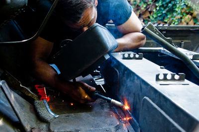 Close-up of manual worker heating metal