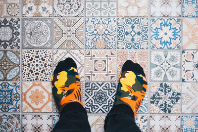 Low section of man standing on tiled floor