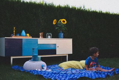 Boy sitting on picnic blanket in lawn