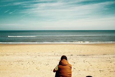 Rear view of woman standing on beach