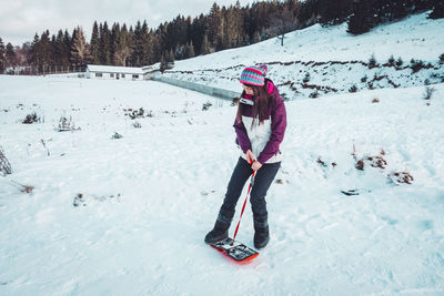 Woman with umbrella on snow covered land