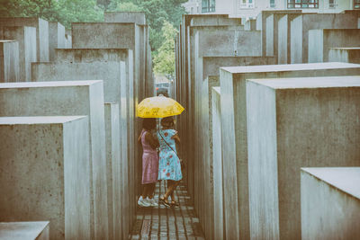 Rear view of woman standing by building