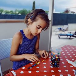 Young woman looking down while sitting on table