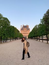 Rear view of woman walking at beach against clear sky