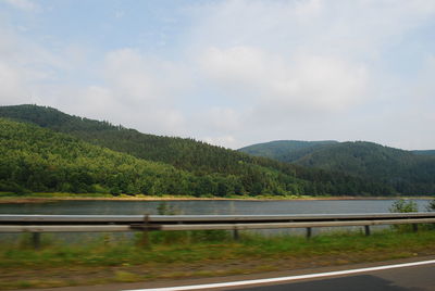 Scenic view of lake by mountains against sky