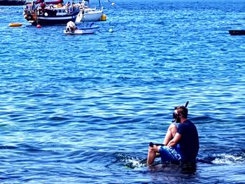 Full length of shirtless man swimming in sea