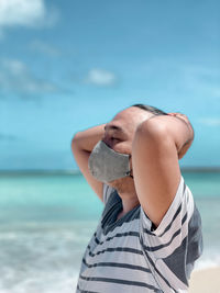 Midsection of man on beach against sky