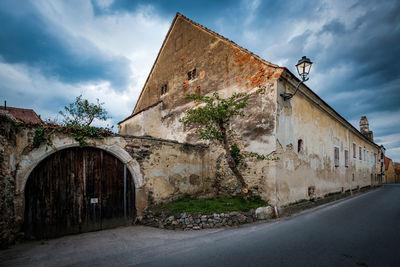 Exterior of old building against cloudy sky