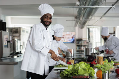 Portrait of smiling chef preparing food in restaurant kitchen