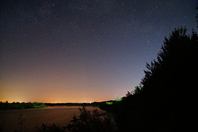 Scenic view of silhouette trees against sky at night