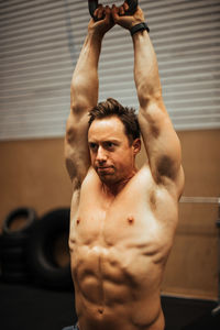 Shirtless man exercising in gym