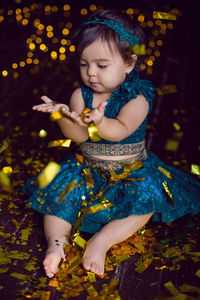 Girl in blue dress in studio with gold sequins and garland