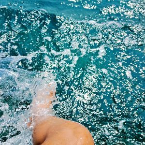 Low section of person standing in swimming pool