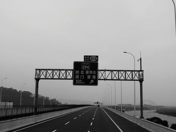 Road sign against sky