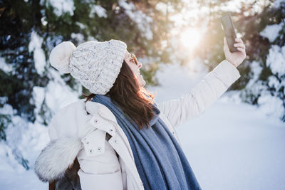 Woman with umbrella standing in snow