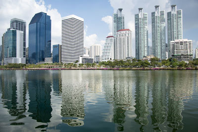 Reflection of buildings in city against sky